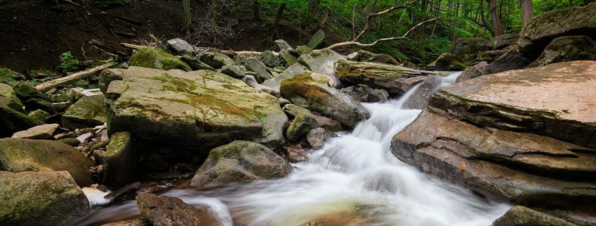 natural creek with fast moving, blurred water